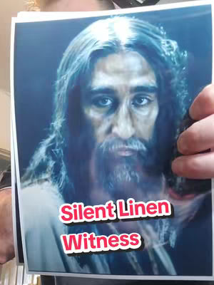 A person holding a printed image of a man, possibly a representation of Jesus, with long hair and a beard. The image is in a blue hue, and the person holding it is partially visible. The image has overlaid text.