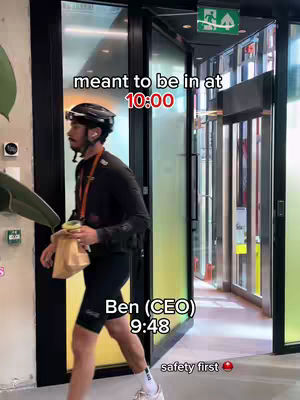A person wearing a helmet is walking towards the camera through a doorway.