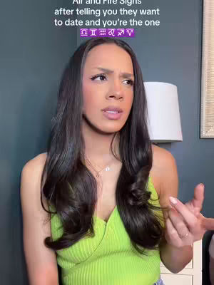 A medium shot shows a woman with long, dark hair looking off to the side with a concerned expression. She wears a light green tank top. The background is a muted blue-grey with a white lamp.