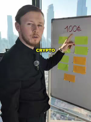 A man in a black shirt stands slightly off-center, pointing at a whiteboard with colorful sticky notes and the text "100€" written on it. The image is shot from the chest up, with a large window showing a city skyline in the background.