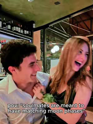 A couple is laughing and embracing each other in a restaurant setting. The man on the left is wearing a white shirt, and the woman is wearing a black dress. Text overlays their scene.
