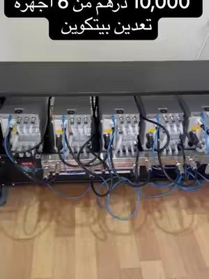 The cover image shows several rectangular gray objects with various wires and ports, suggesting technical equipment, possibly for cryptocurrency mining. The objects sit on a surface that appears to be made of wood. The background is a light-colored wall or surface.