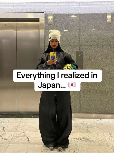 A young woman in a beanie and dark clothing stands in an elevator, holding a phone, with text overlayed. The overall composition has a modern feel.