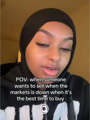 The cover image features a close-up of a woman's face against a dimly lit background. She is wearing a black head covering and a black hoodie with a silver pendant. Text overlay includes "POV: when someone wants to sell when the markets is down when it's the best time to buy".