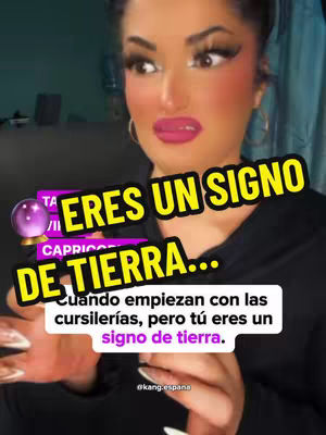 The cover image features a woman looking to the side with an expression of slight surprise. Overlayed text includes 'Eres un Signo de Tierra...' and additional text in a rectangular box below describing the scenario. A graphic of a purple crystal ball is on the leftmost corner of the text. The image has soft lighting and a blurred background.