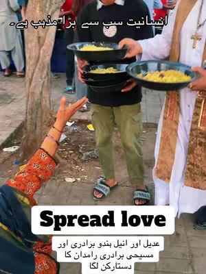 The image shows three individuals offering food to people from black trays, with an outdoor setting. A person closest to the viewer is holding their hand up, seemingly reaching out. The text over the image says spread love.