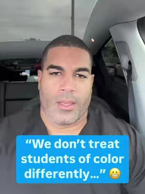 A man with short hair looks at the camera while sitting in a car. A rectangular text overlay in a blue box is positioned at the bottom, stating, "We don’t treat students of color differently…" and includes a slightly worried face emoji.