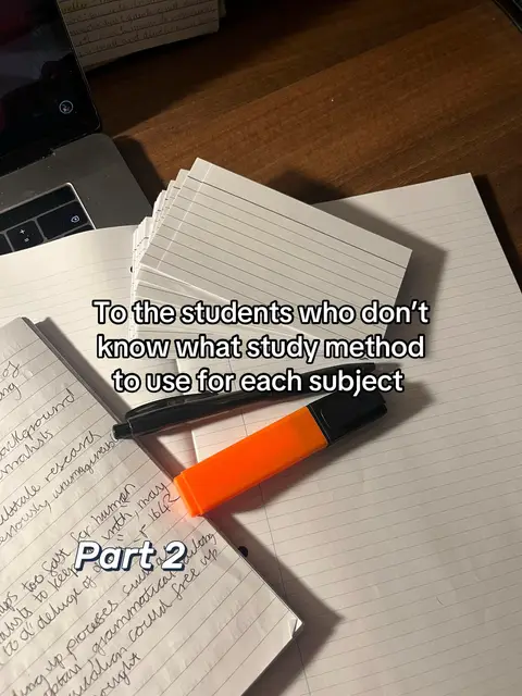 The image features a top-down view of a desk, covered in notebooks, lined paper, and stationery items. At the base of the image, there's a notebook with handwritten notes. Overlaid are several packs of lined paper, and pens. An orange highlighter sits prominently on the paper. Text overlays are in the middle, describing a study method.