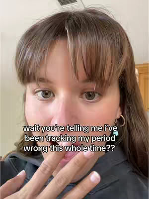 A close-up shot of a woman’s face with a distressed expression. Text overlays are positioned on the image. The woman has long brown hair with bangs, and she is wearing a dark-colored top. Her hand is near her mouth, with a look of questioning. The background is blurred, suggesting an indoor setting.