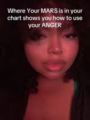 A close-up shot of a person's face looking slightly upwards, with a warm, reddish hue dominating the lighting. The person has dark hair and is wearing a nose ring and visible eye makeup. Text is overlaid at the top, with the words "Where Your MARS is in your chart shows you how to use your ANGER".