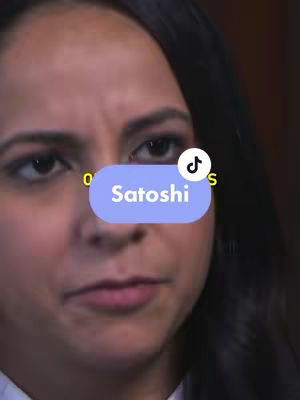 A close-up shot of a woman with dark hair and a neutral expression. A blue oval-shaped text box with the word "Satoshi" is overlaid near the center of the image. A TikTok watermark is in the upper right corner.