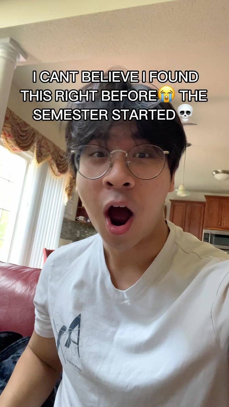 A young man with glasses and a white t-shirt is shown inside a home. The man has his mouth wide open in an expression of surprise. Text is overlaid on the image.