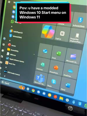 The cover image shows a close-up of a laptop screen displaying Windows 11 with a modified Windows 10 Start menu. A text overlay in a black box reads "Pov: u have a modded Windows 10 Start menu on Windows 11". The Start menu features various app icons. A keyboard is visible in the bottom of the image.