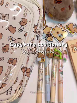 The cover image showcases an array of cute stationery items arranged on a white surface. The primary focus is on pens adorned with capybara-themed charms. A clear pencil case filled with capybara and bear illustrations lies in the background. Stickers, small notepads, and other stationery accessories with the same theme are spread around, suggesting an inviting desktop setup for studying or creative work. The overall presentation is neat and appealing, using soft colors and a clean composition to attract attention.