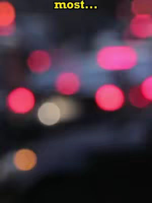 An out-of-focus image with a dark background and multiple blurred circular lights of varying colors, mostly red and a few pink and white lights. The word "most..." is overlaid on the top.