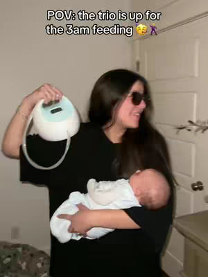 A woman wearing sunglasses holds a baby in her arms and a breast pump in the other hand. The woman is smiling with text overlayed on the image.