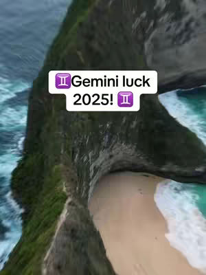 An aerial view of a coastline featuring a mix of green, brown, and white. The upper portion of the image is dominated by a dark green, rocky cliff that slopes down towards a light beige beach. The beach is nestled between the cliff and a vivid turquoise sea. A text overlay in a white rectangle with a purple Gemini symbol announces 'Gemini luck 2025!'