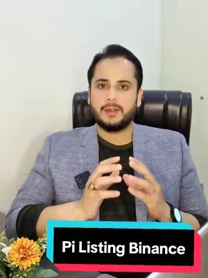 A man with a beard and short dark hair sits in a chair with a light-colored wall behind him. He wears a black shirt under a light grey blazer. A rectangular bar with the text 'Pi Listing Binance' covers his lap.