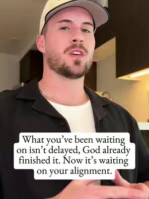 A man wearing a backwards baseball cap and a black shirt is speaking directly to the camera. Text appears in front of him in a white box.