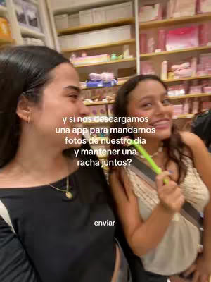 Two women are shown in a well-lit retail setting. The frame focuses on the two women in a medium shot, captured from the chest up. The woman on the left is turned towards the left, gazing off-camera, while the woman on the right is looking and smiling towards the camera. The shelves in background are filled with products, suggesting a retail location. Text is overlaid on image.