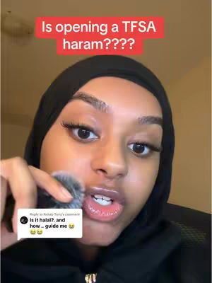A close-up shot of a woman with glossy lips and long eyelashes. She wears a black hijab and a black top. A text overlay in a red box asks 'Is opening a TFSA haram????'. Her hand holds a makeup brush. A comment bubble at the bottom contains text from a user.