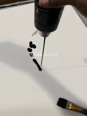 A hand holding a black bottle is pouring black liquid onto a white surface. The liquid forms a few circular blobs and a longer streak. A paintbrush is placed on the bottom right corner, with the brush end covered in black. The text "Mark 2:2-12" is written in light grey in the center.