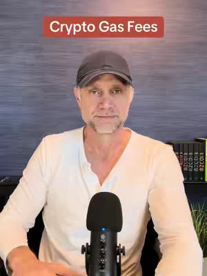 A man with a gray cap and a white shirt is seated in a studio setting, with a microphone in front of him and a text overlay at the top that reads 'Crypto Gas Fees'.