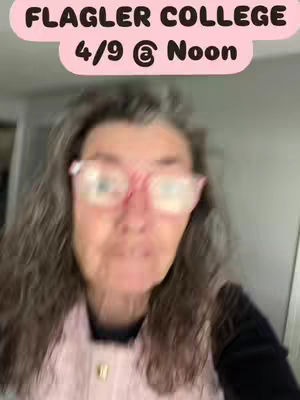A blurred selfie showing a woman with long, wavy gray hair and pink-framed glasses. She is wearing a pink top and is centered in the frame. The upper part of the image has a pink box with text.