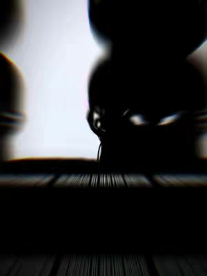 The image is a very dark, abstract composition. Dominant colors are black and white, creating high contrast. The foreground appears to be a textured surface, possibly wood, with vertical lines. The background is a bright, white space that is partially obscured by silhouetted dark figures. The focus is blurred, with most of the image being out of focus, adding an air of mystery and depth. The silhouettes suggest a person or object.