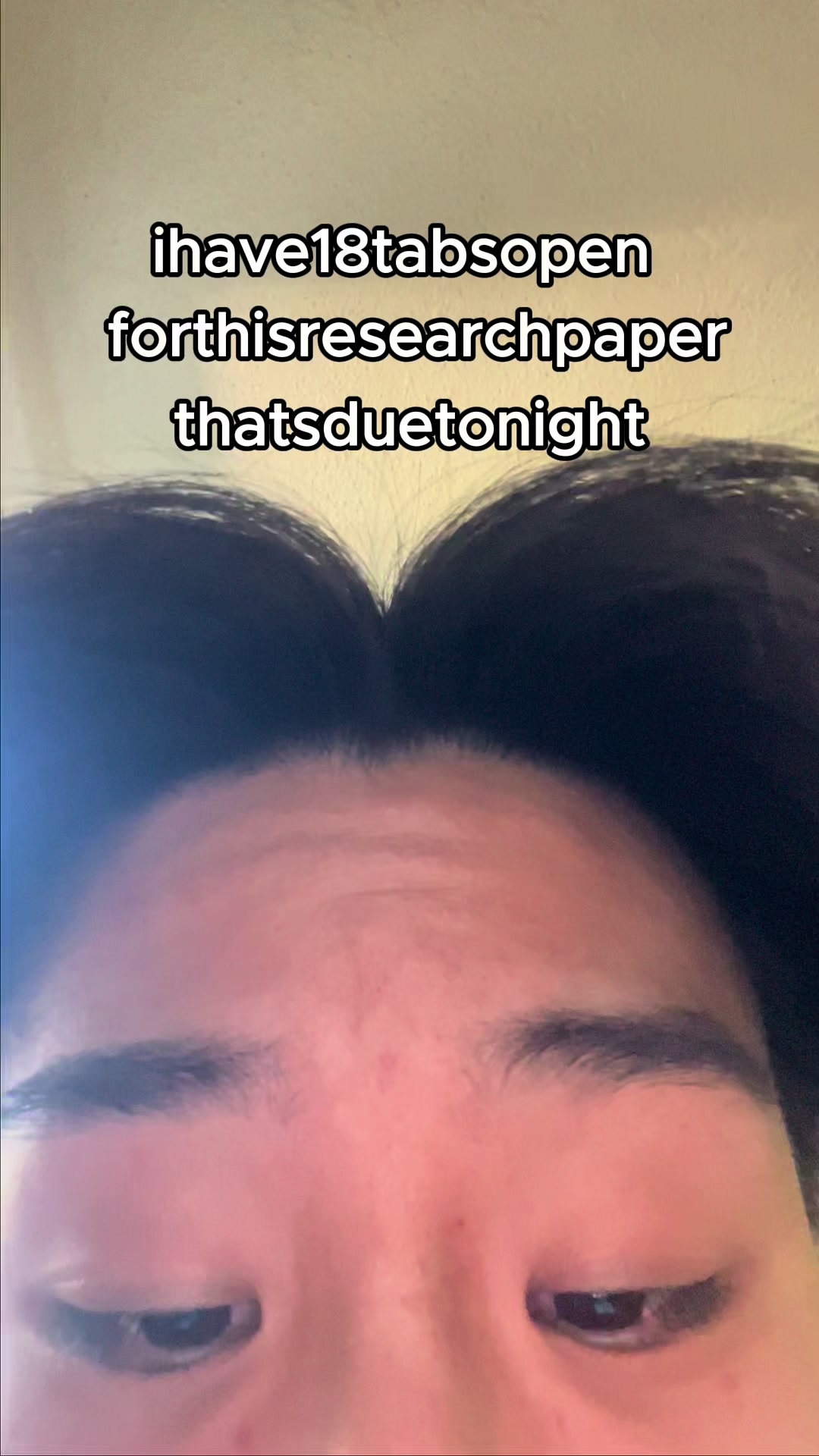 The cover image shows a close-up view of a person's face, angled from slightly below. The focus is primarily on the forehead, eyebrows, and eyes, with the top of the head and a portion of the face visible. The skin tone appears to be light. Overlaying the image is white text that reads 'ihave18tabsopen forthisresearchpaper thatsduetonight'. The background is a plain, light-colored surface.