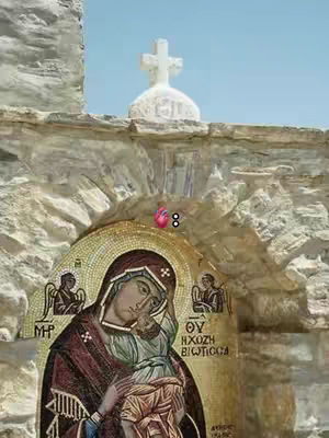 The cover image shows a religious mosaic on a stone wall. At the top is a white cross above a white-domed structure, against a clear blue sky. Below, a mosaic depicts a woman holding a child, likely a depiction of Mary and Jesus. The mosaic is composed of various colors, including gold, brown, and red. The overall composition is centered and symmetrical.