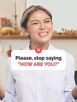 A woman with fair skin and long dark hair with blonde highlights, wearing a white button-down shirt, makes a surprised or questioning face while looking at the camera. A white rectangle with red "X" and text overlay is positioned over her upper body.