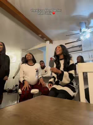 The image shows a room with multiple people, two women are highlighted, with the caption 'there's no blend better than family' overlaid at the top.