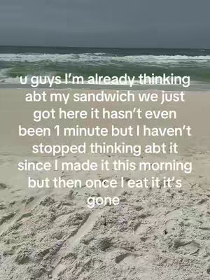 The image shows a beach scene with a sandy foreground leading to the ocean, and text overlayed in the middle. The sky is overcast, and the water has small waves.