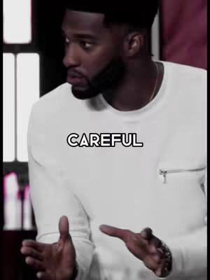The image features a Black man wearing a white sweater, his gaze slightly averted, and his hands outstretched as if presenting or gesturing. The word "CAREFUL" is overlaid on the image in a bold, white font with a black outline. The overall composition has a slightly shadowed or low-light appearance.