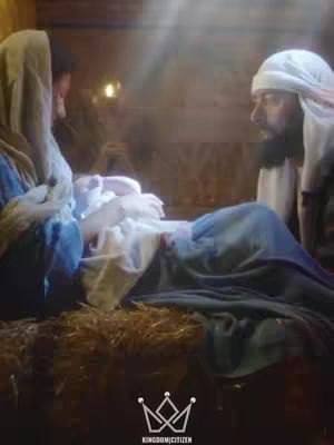 An image depicting the nativity scene. Mary is on the left holding baby Jesus wrapped in swaddling clothes, Joseph is on the right looking at baby Jesus . The scene is set in a manger with a warm glow, suggesting a humble setting.