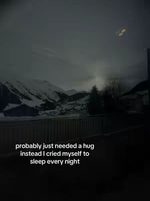 The image shows a landscape through a window with snow-covered mountains, and a dark sky. The overlay text at the bottom reads "probably just needed a hug instead I cried myself to sleep every night". The overall tone is somber and reflective.