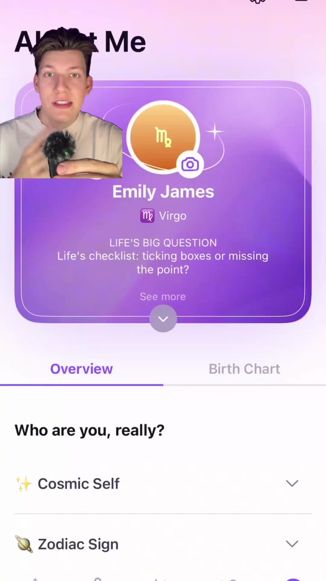 The cover image features a man with fair skin and short dark hair positioned in the foreground, holding a microphone. Behind him, there's an interface of an app, with a purple and white gradient background. The interface shows profile information including the name "Emily James", a symbol of the Virgo zodiac sign, and the phrase "LIFE'S BIG QUESTION". The layout includes sections labeled "Overview" and "Birth Chart", and the text "Who are you, really?", with the overall composition being a blend of selfie-style and app interface design.