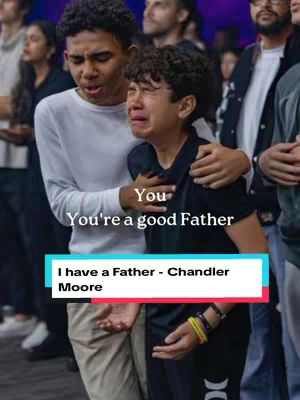 Two young men are embracing, one consoling the other who is crying. Behind them are a crowd of people, some looking on. At the bottom is a text element on a blue background.