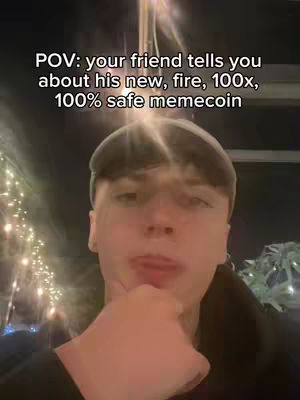A selfie-style shot featuring a young man looking slightly to the left with a hand near his face. The background is blurry and lit by warm-toned lights.