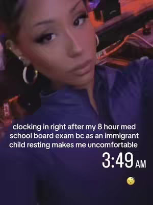 A selfie-style shot of a person, angled upwards. They have a neutral expression and are wearing a dark blue top and large hoop earrings. Text overlays indicate the time and some life context for the person at that moment.