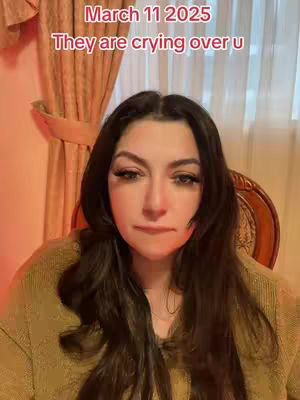 A medium shot of a woman looking towards the camera with a neutral expression. Overlayed text indicates a date and a message about crying. She is wearing a light colored top. Behind her are light-colored curtains.
