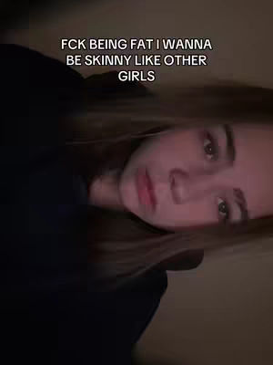 The cover image features a young woman in a close-up shot. She is looking down towards the camera, with a partially visible dark top adding to the image's somber tone. Overlayed text at the top reads "FCK BEING FAT I WANNA BE SKINNY LIKE OTHER GIRLS."