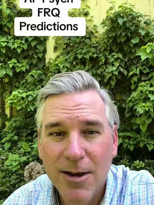 A man with short, graying hair and a light complexion looks directly at the camera. He's wearing a blue and white checkered shirt. Behind him, lush, green foliage serves as a backdrop, the leaves densely packed. A white rectangular box with black text floats above the man's head, reading “AP Psych FRQ Predictions".