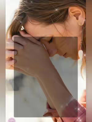The cover image shows a close-up of a person, likely a woman, with dark hair, with their head tilted down. Her hands are clasped together near her face, as if in prayer or contemplation. The scene is softly lit, with a blurred background.