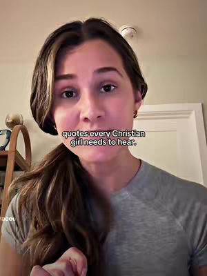 A woman with long brown hair is the focus of the image. She's in a room with soft lighting. She is wearing a gray t-shirt. Overlayed on the image is text in a white box.