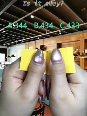 The cover image shows a close-up of a person's hands holding two yellow sticky notes, shaped like a book. The image is framed from a first-person perspective. Above, there is text that says, “Is it easy?” and followed by three options, A, B, and C, each followed by a number. The background is blurred, showing an indoor commercial setting.
