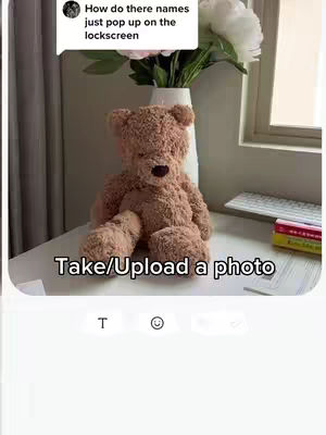 The image shows a teddy bear sitting on a white surface in front of a window. A comment box with text is in the top left corner, and the words "Take/Upload a photo" are overlaid at the bottom.