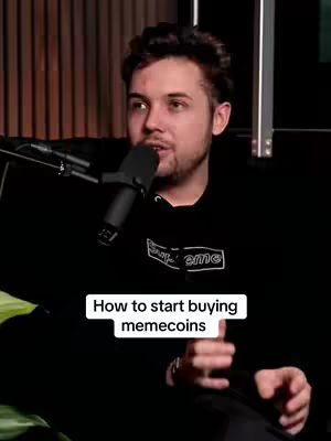 A man with dark hair is holding a microphone in front of him. He's wearing a black hoodie with the words "Supreme" on it. There is text at the bottom of the image that says, "How to start buying memecoins". The background is a dark space with wooden panels visible.