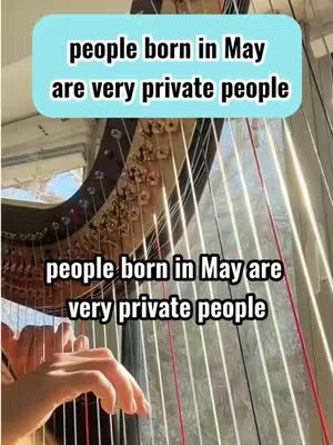 The cover image shows a close-up view of a harp with hands playing the strings. Overlaid on the image are text boxes with the words "people born in May are very private people."